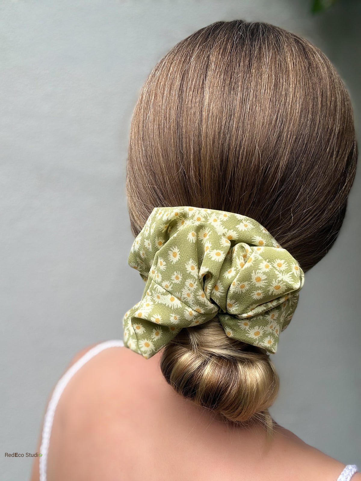 Matcha Daisy oversized silk scrunchie over a low bun, back view showing the green daisy print