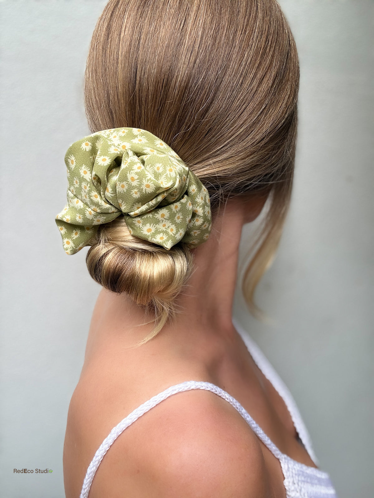 Matcha Daisy oversized silk scrunchie wrapped around a low bun, side profile, styled with a white summer top