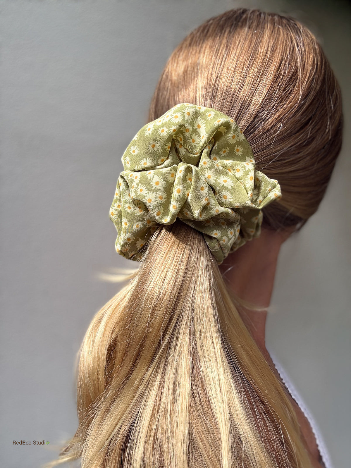 Matcha Daisy oversized pure silk scrunchie on a low ponytail in sunlight, three-quarter back view showing its full volume