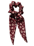 Merlot Daisy classic silk scarf scrunchie with detachable tails, flat lay showing cream daisies with rust-orange centres on burgundy satin