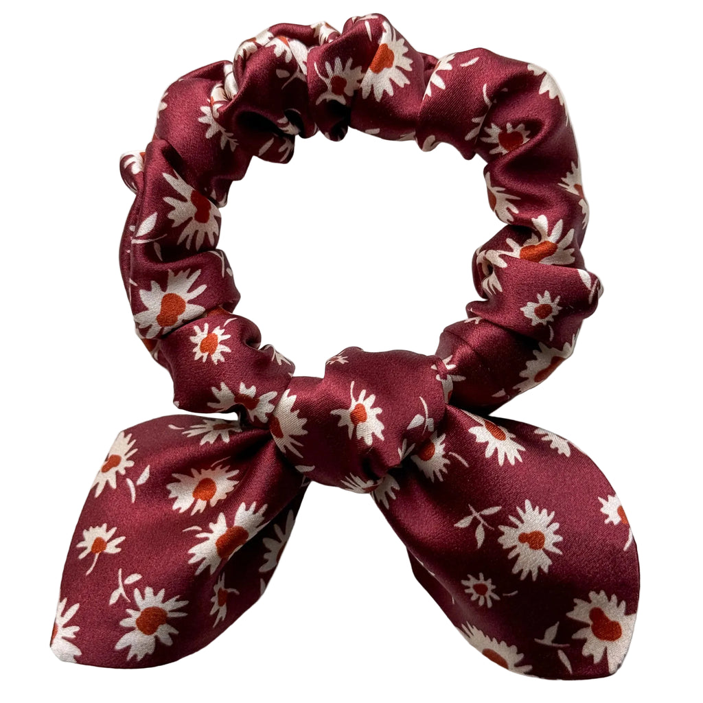 Merlot Daisy mini silk bow scrunchie, flat lay top view showing cream daisies with rust-orange centres on burgundy satin