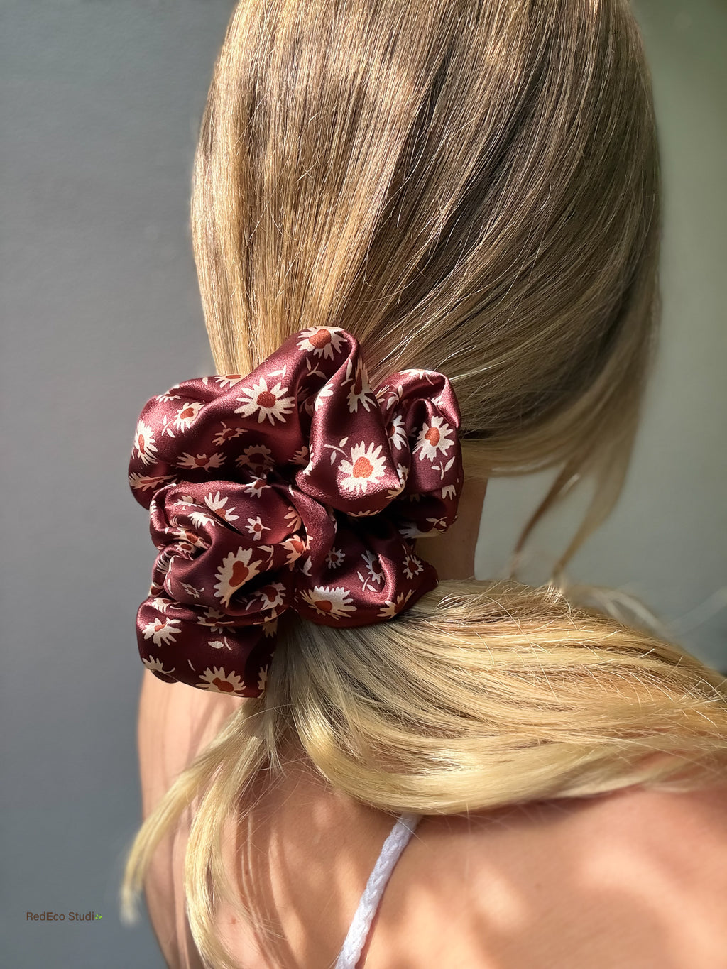 Merlot Daisy oversized silk scrunchie on a low side ponytail worn over the shoulder, styled with a white crochet top