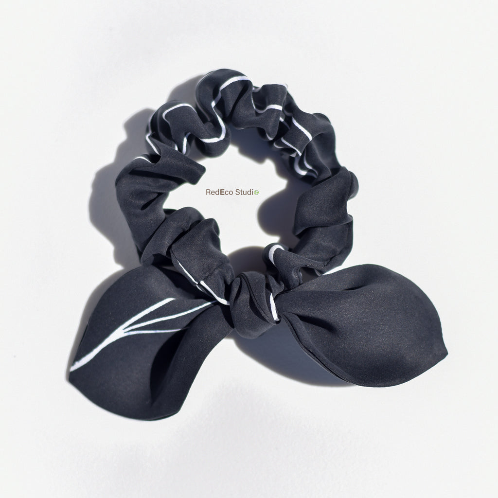 Black silk scrunchie with bow on a white background