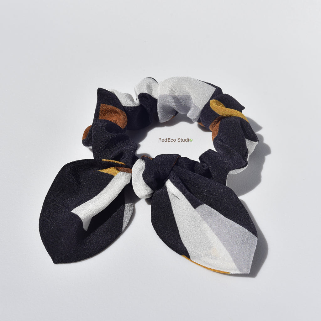 Black, white, and brown scrunchie on a light gray background