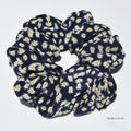 Large navy blue silk scrunchie with white floral pattern on a white background