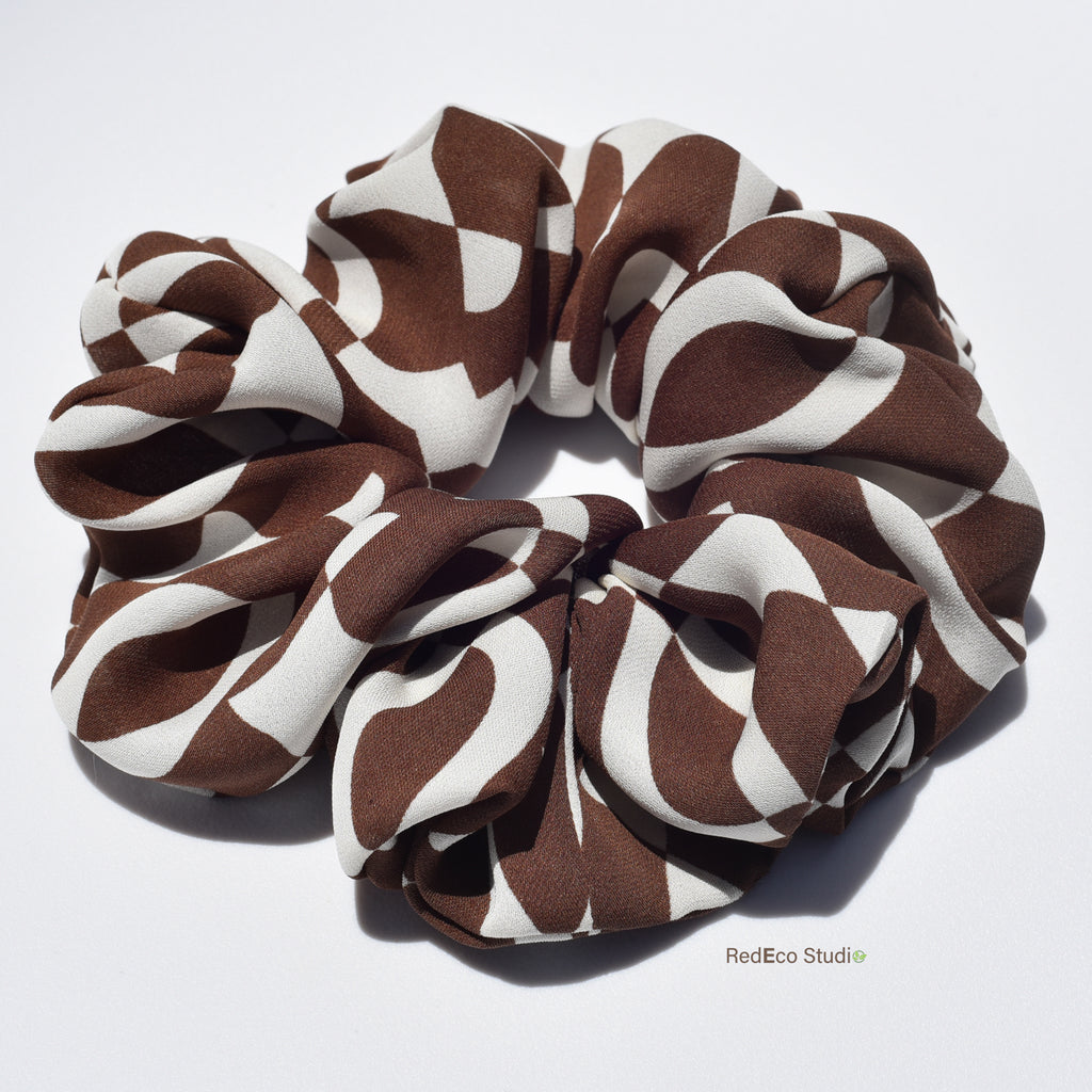 Large brown and white patterned silk scrunchie on a white background