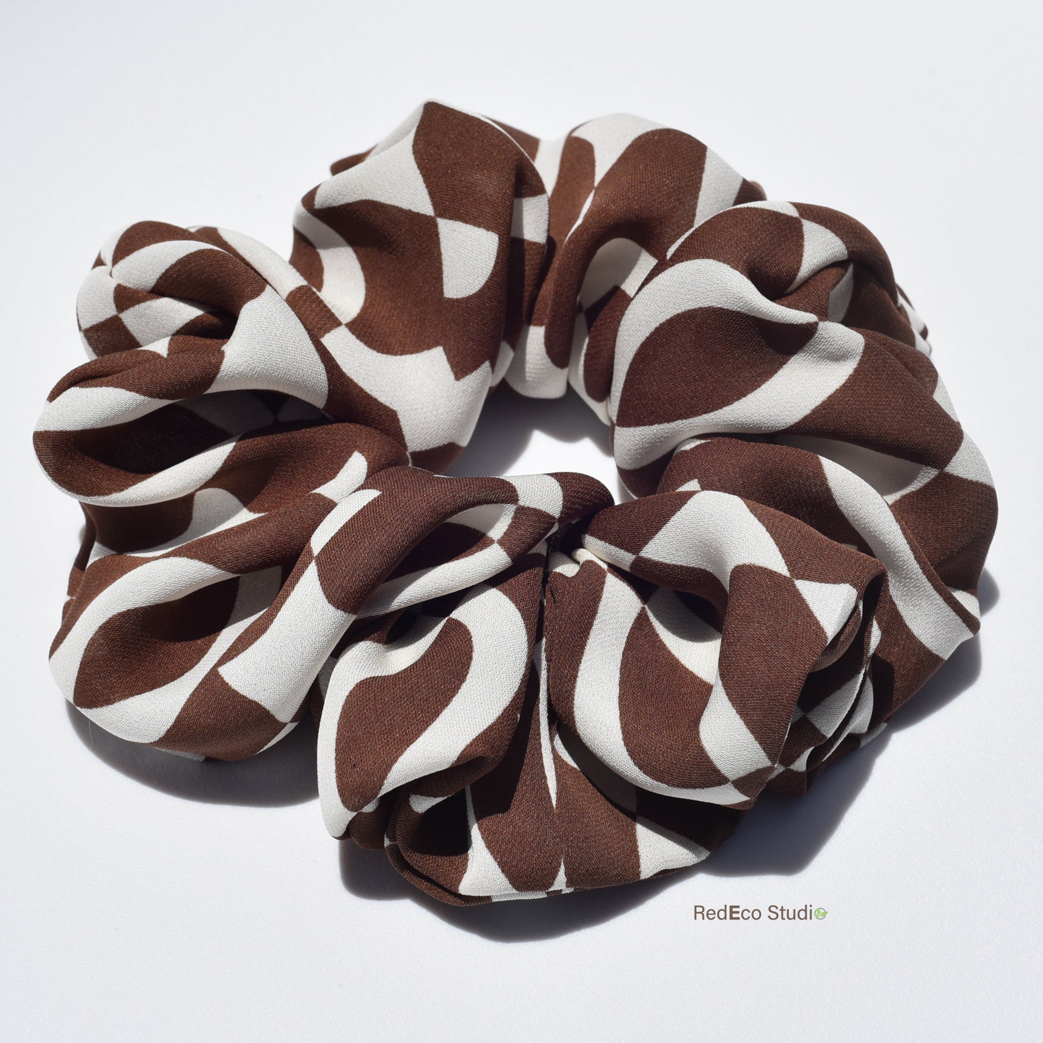 Large brown and white patterned silk scrunchie on a white background