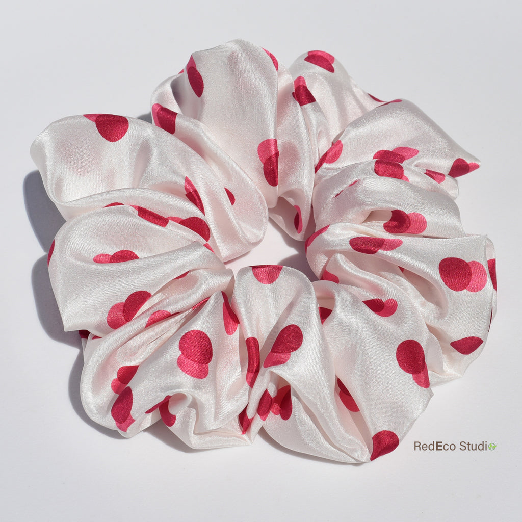White silk scrunchie with two-tone red spots on a white background