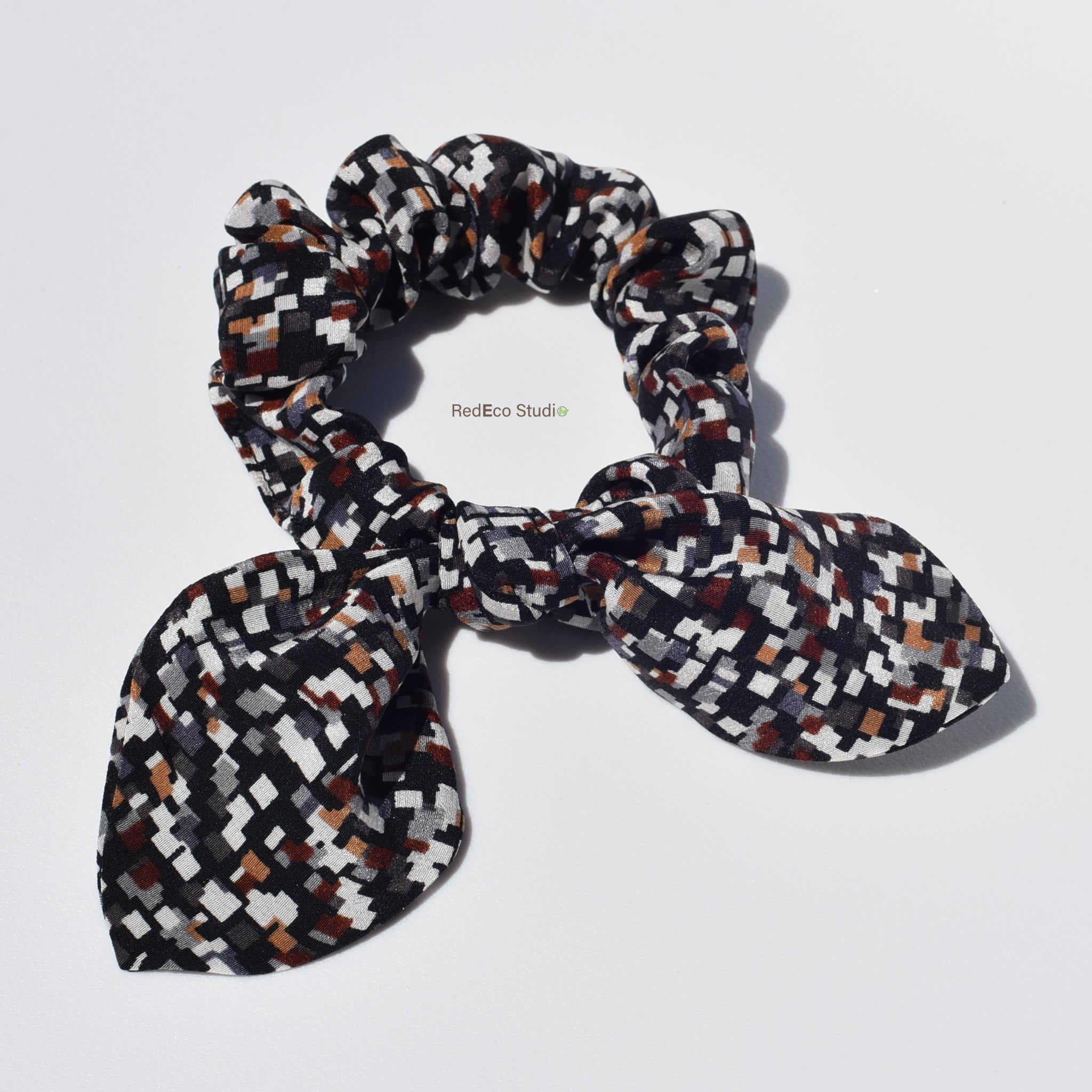 Patterned silk scrunchie with bow on a white background