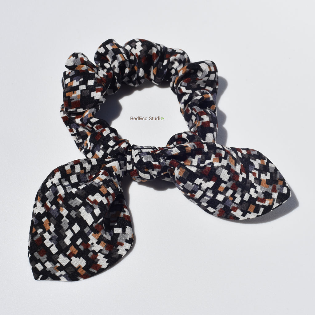 Patterned silk scrunchie with bow on a white background