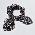 Patterned silk scrunchie with bow on a white background