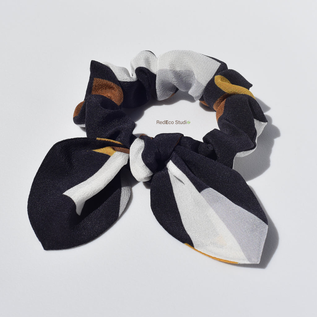 Patterned silk hair scrunchies with a bow on a light gray background