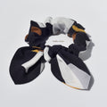 Patterned silk hair scrunchies with a bow on a light gray background