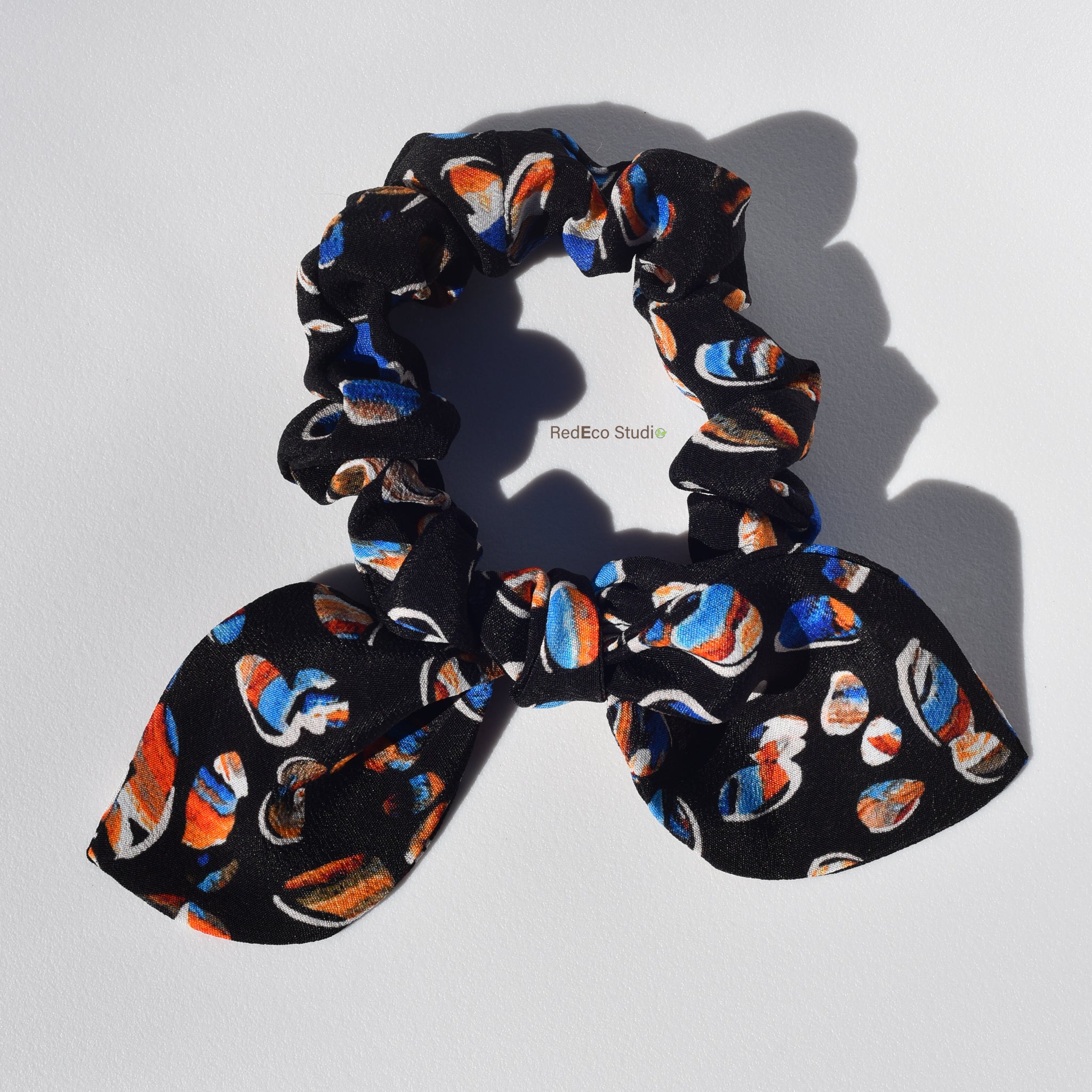 Silk scrunchie with colorful pattern on a white background