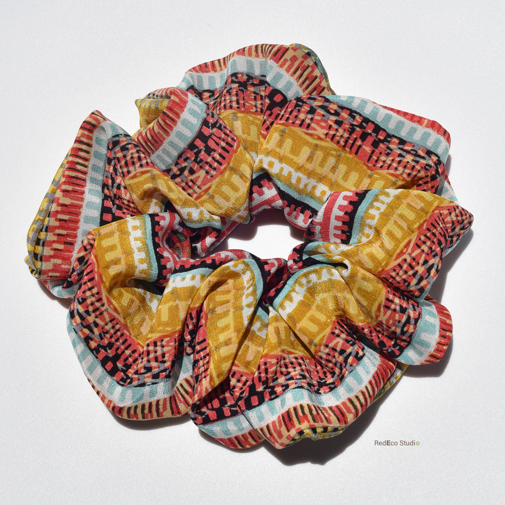 Colorful patterned silk scrunchies on a white background