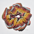 Colorful patterned silk scrunchies on a white background
