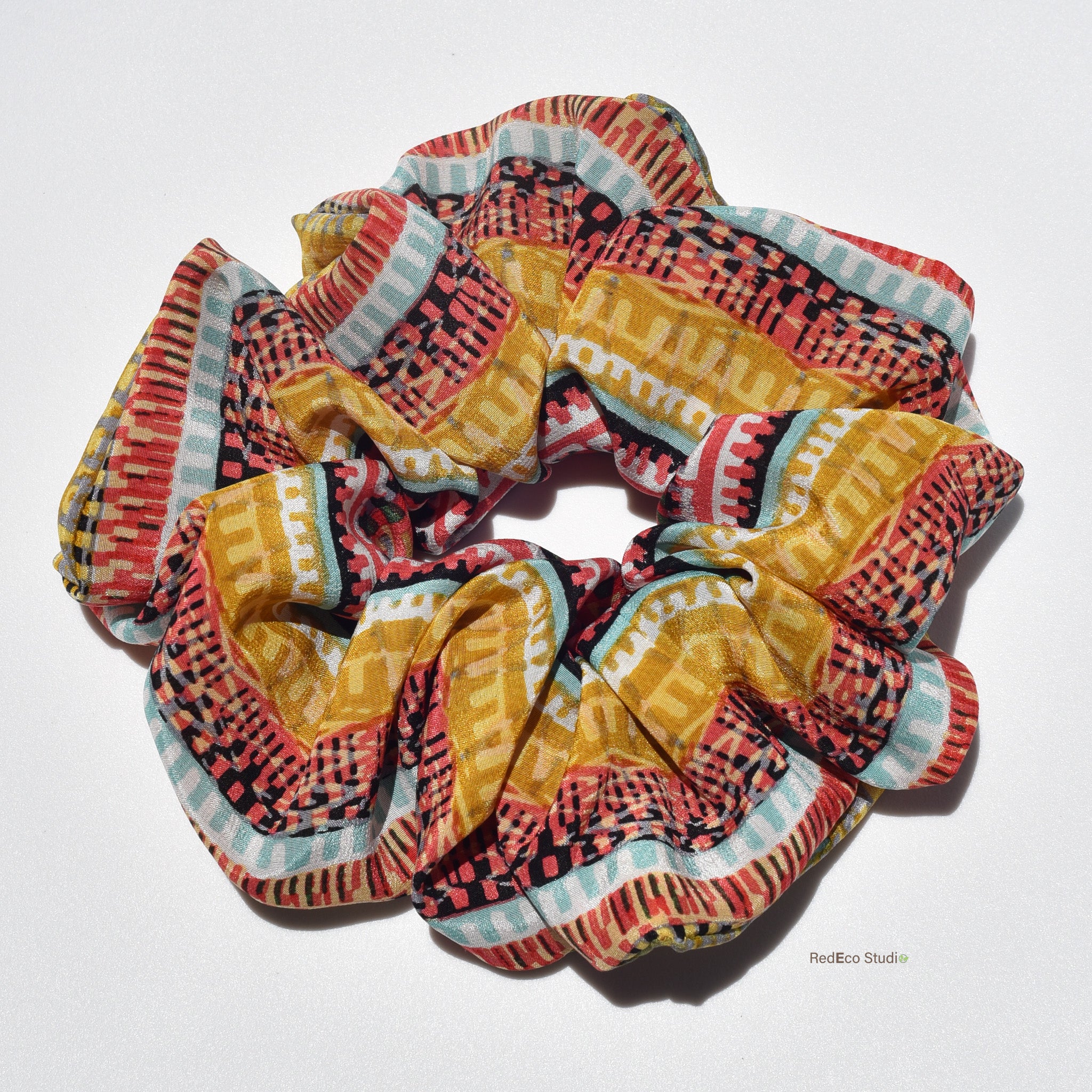Colorful patterned silk scrunchies on a white background