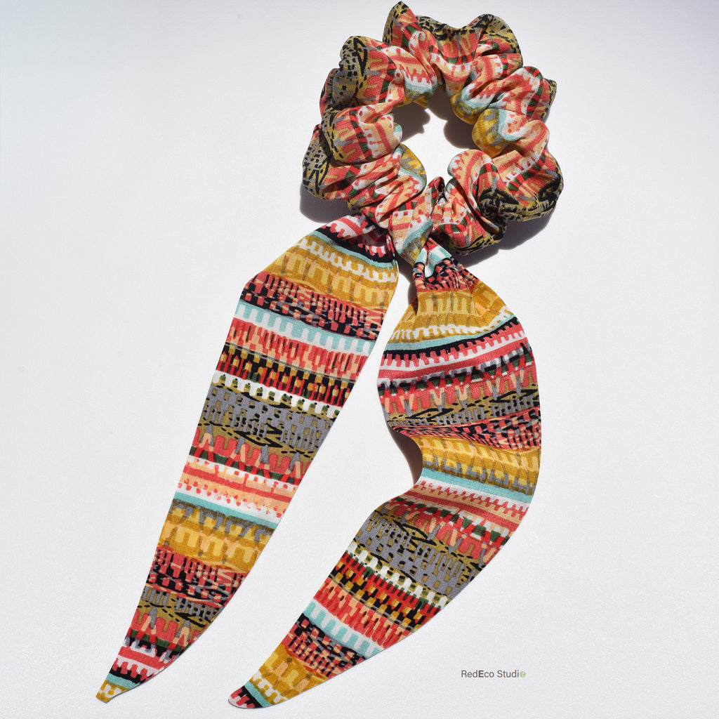 Colorful patterned silk scrunchie on a white background