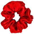 Red satin scrunchie on a light gray background