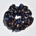 Large silk scrunchie with colorful pattern on a white background