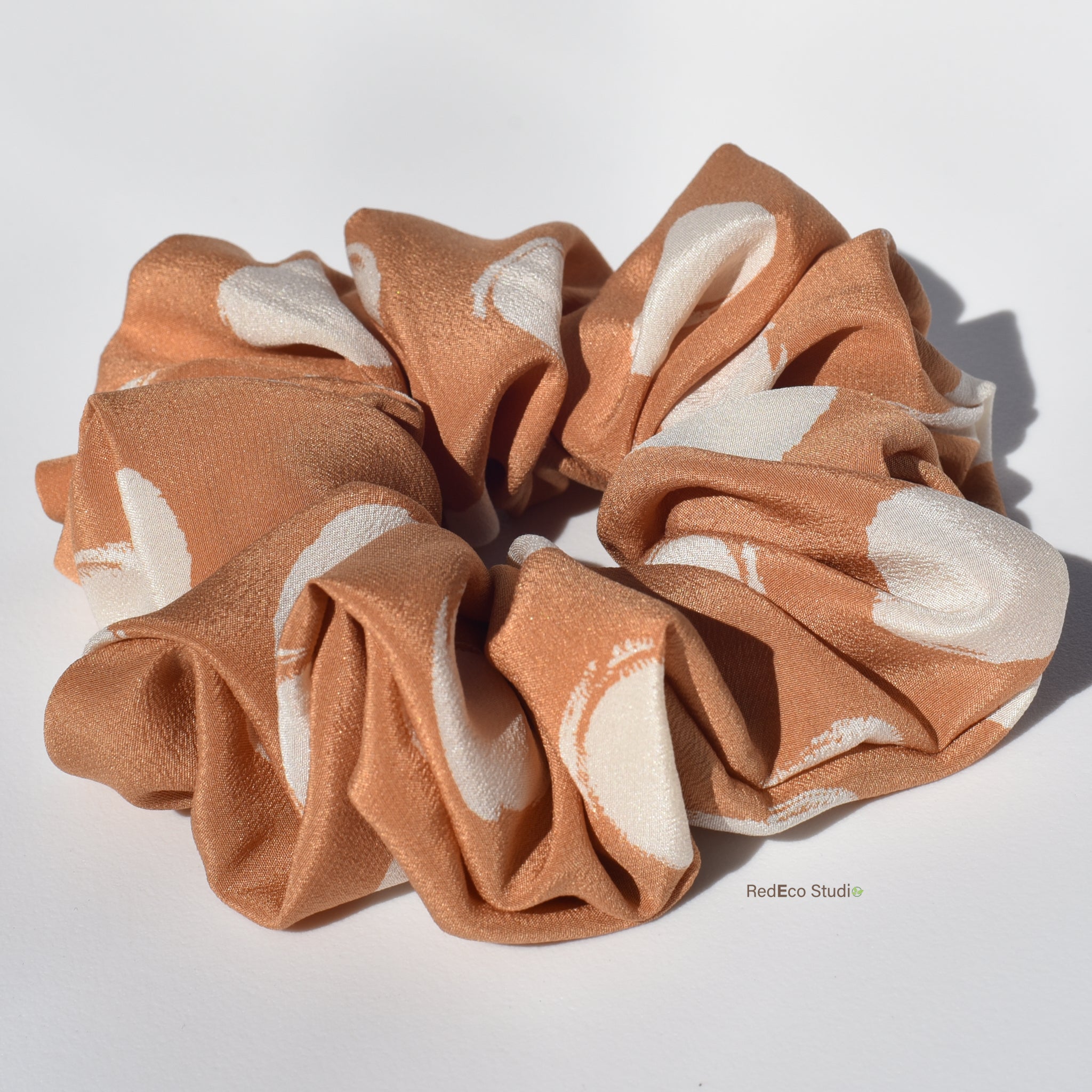 Large Brown scrunchie with white abstract patterns on a white background