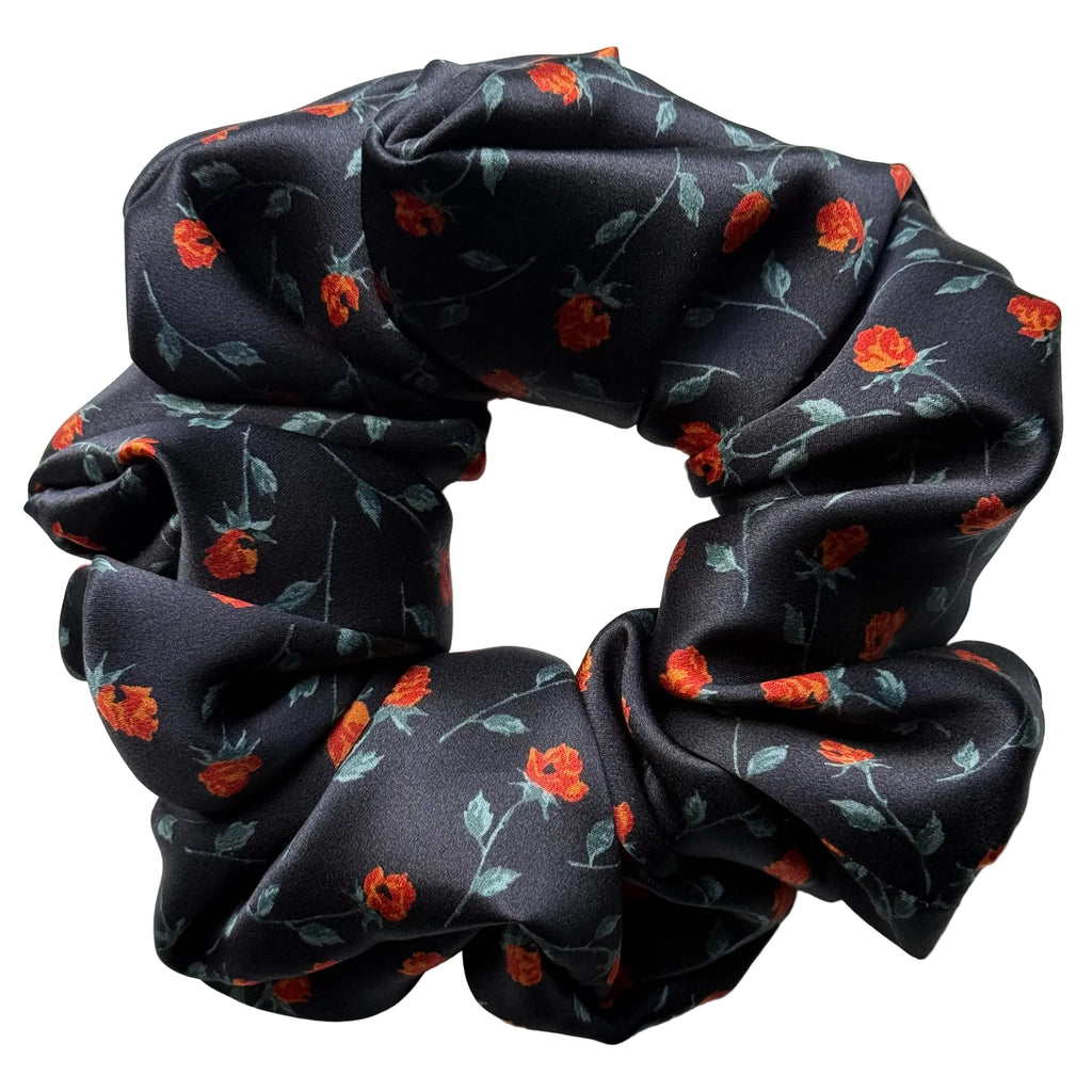 Rosebud Noir oversized silk satin scrunchie, flat lay top view showing the red rosebud print on black