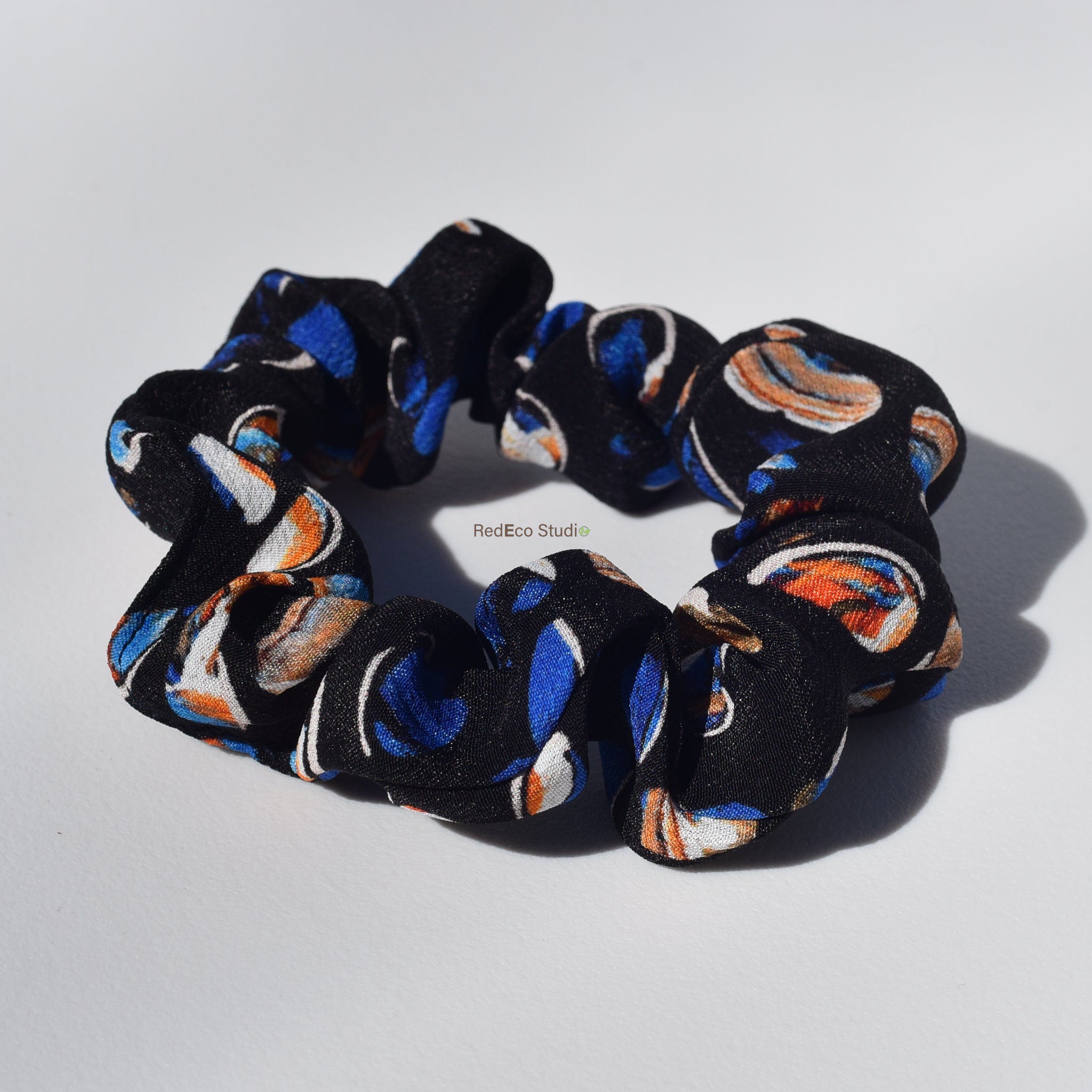 Silk scrunchie with colorful pattern on a white background