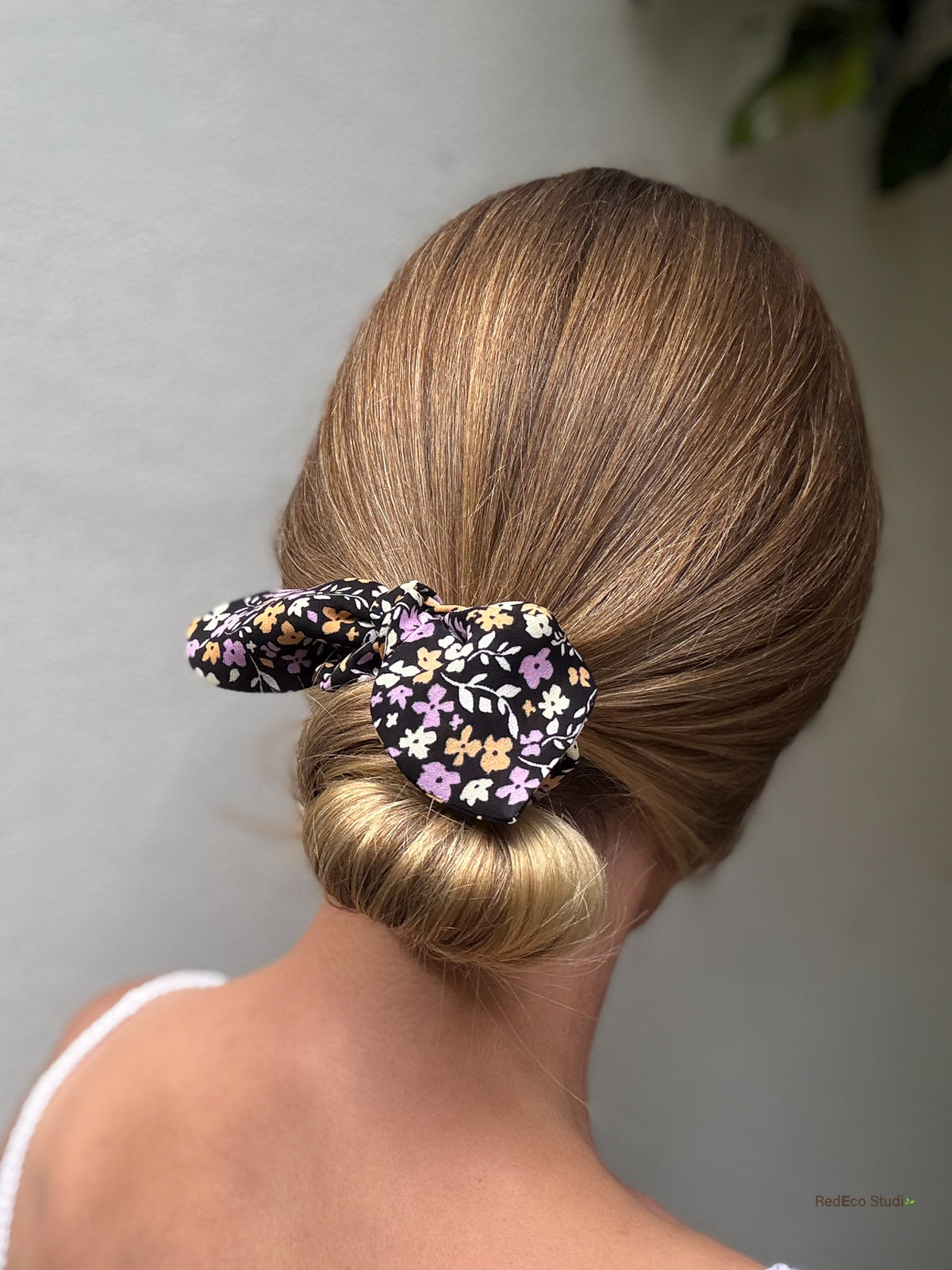 Violet Meadow mini silk georgette bow scrunchie worn on a low bun, lilac, apricot and cream flowers on black