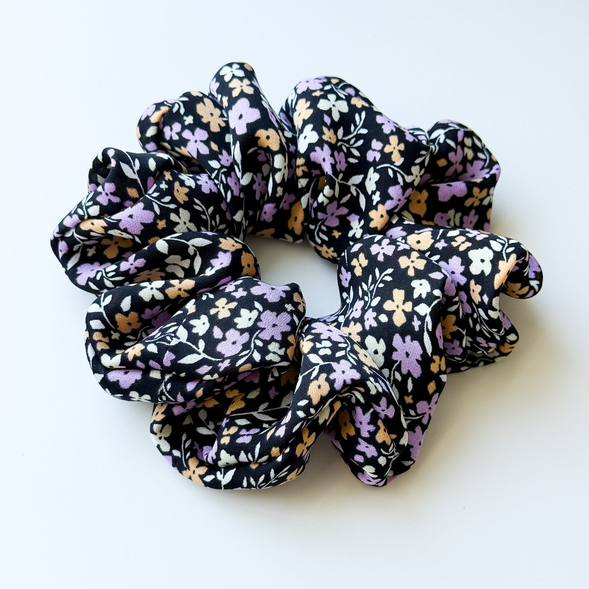 Violet Meadow oversized silk scrunchie, angled view showing its full gathers and the black floral print