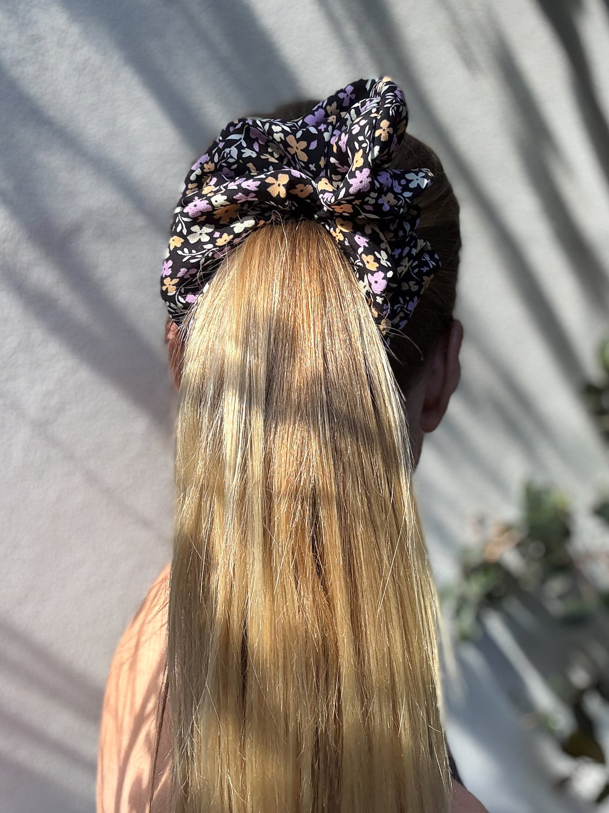 Violet Meadow oversized silk scrunchie on a high ponytail, back view, lilac and apricot flowers on black